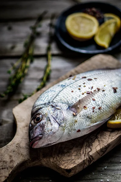 Fresh sea bream on wooden board — Stock Photo, Image