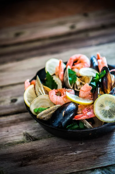 Mischung aus Muscheln, Venusmuscheln und Garnelen auf hölzernem Hintergrund — Stockfoto