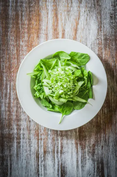 Ispanak, salatalık ve ahşap arka plan üzerinde microgreens salatası — Stok fotoğraf