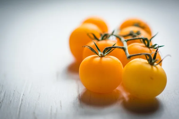 Ahşap arka plan asma üzerinde sarı domates — Stok fotoğraf