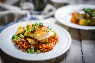 Kavrulmuş hake romesco sos ve ahşap zemin üzerine soğan ile