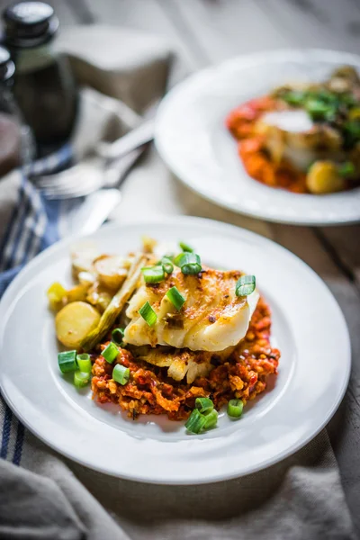 Roasted hake with romesco sauce and onion on wooden background — Stock Photo, Image