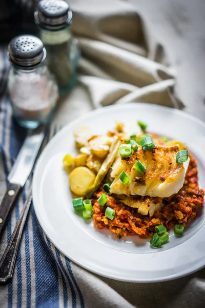 Nasello arrosto con salsa romesco e cipolla su fondo di legno — Foto Stock