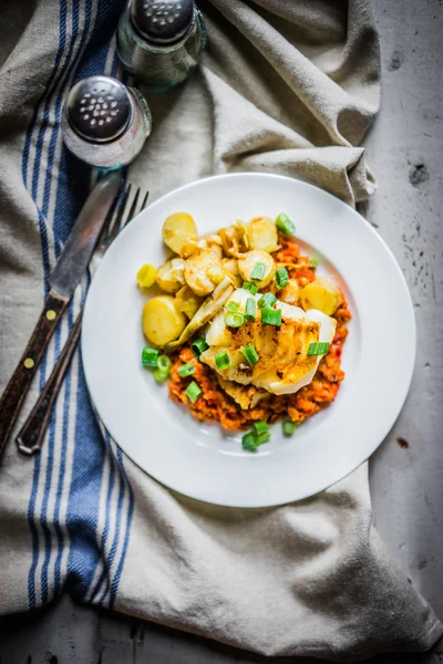 Roasted hake with romesco sauce and onion on wooden background — Stock Photo, Image