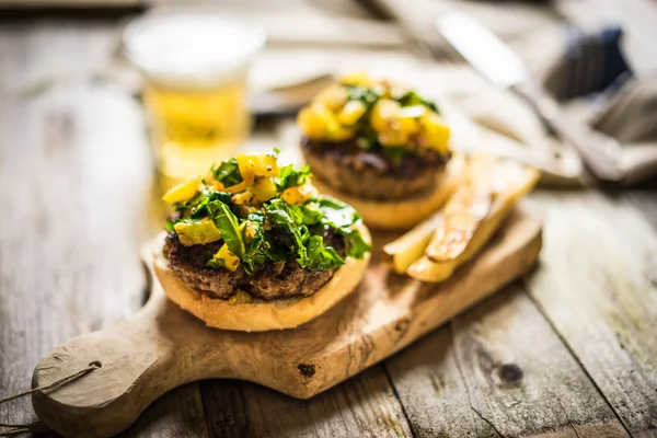 Hamburger fatti in casa con patatine fritte su sfondo di legno — Foto Stock