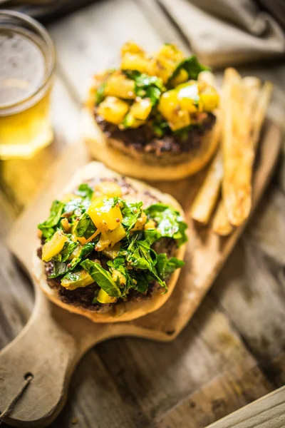 Hamburger fatti in casa con patatine fritte su sfondo di legno — Foto Stock