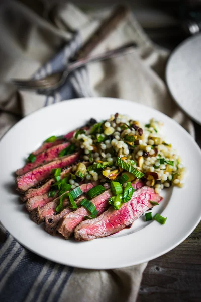 Sliced steak with couscous and vegetables — Stock Photo, Image