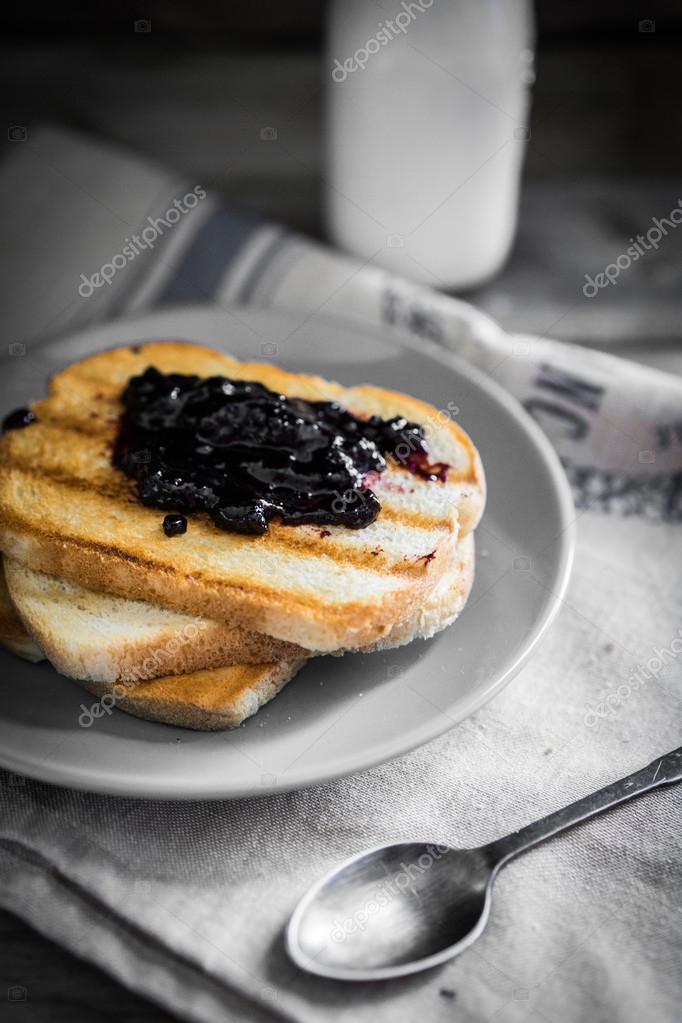 Toastbrot mit Marmelade und Milch auf Holzboden — Stockfoto © ehaurylik
