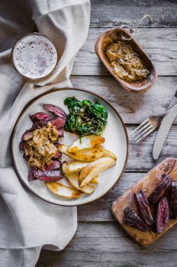 Biftek pişmiş botatoes ve ahşap zemin üzerine yeşil salata