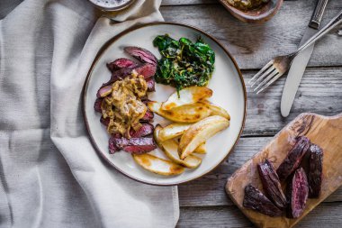 Biftek pişmiş botatoes ve ahşap zemin üzerine yeşil salata