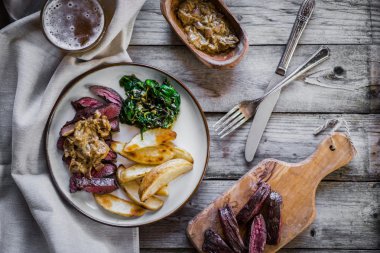 Biftek pişmiş botatoes ve ahşap zemin üzerine yeşil salata