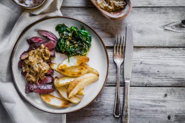 Biftek pişmiş botatoes ve ahşap zemin üzerine yeşil salata