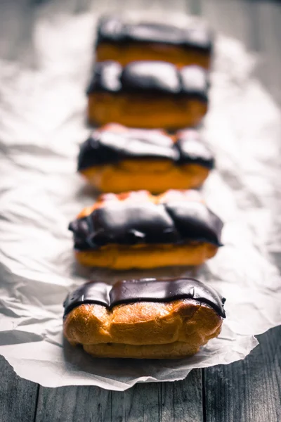 Eclairs on rustic background — Stock Photo, Image