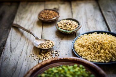 Bezelye, kahverengi pirinç, quinoa ve buğday ahşap arka plan üzerinde