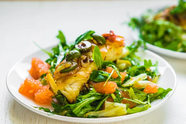 Poisson grillé avec salade de roquette — Photo