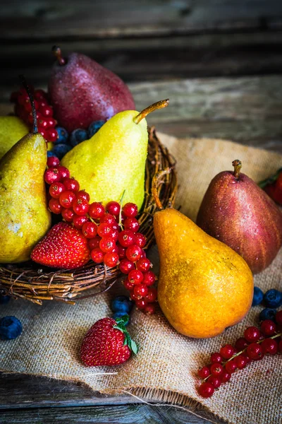 Pears with berries on wooden background — Stock Photo, Image