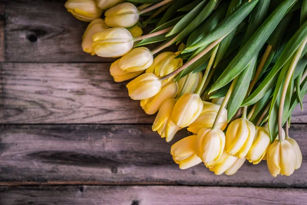 Gele tulpen op houten achtergrond — Stockfoto