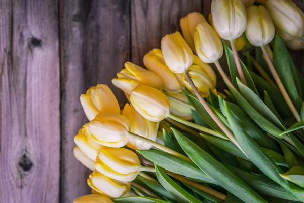 Yellow tulips on wooden background — Stock Photo, Image