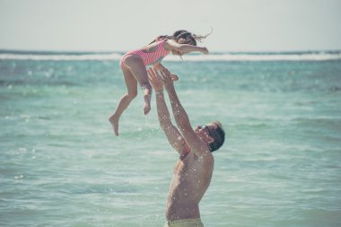 Father and daughter at the ocean clipart