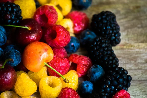 Mix of berries on wooden background — Stock Photo, Image