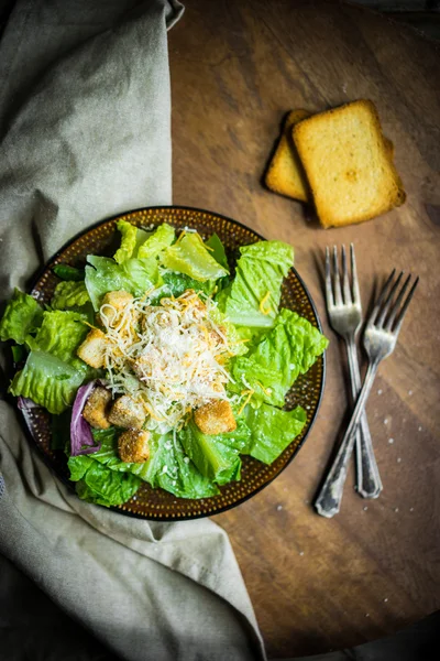 Salada Caesar em fundo rústico — Fotografia de Stock