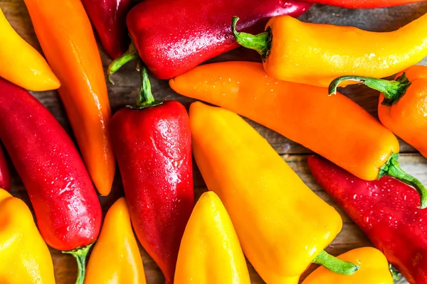 Colorful peppers on rustic background — Stock Photo, Image