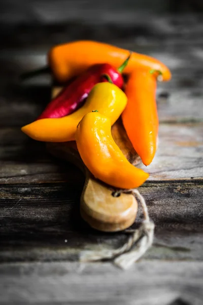 Kleurrijke paprika's op rustieke achtergrond — Stockfoto