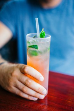 Genç adam kokteyl açık havada içiyor