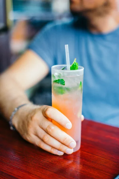 Junger Mann trinkt Cocktail im Freien — Stockfoto
