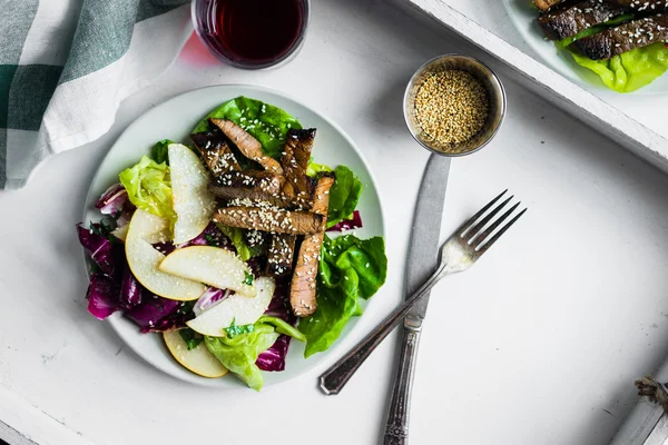 Sliced meat steak with green salad and pears — Stock Photo, Image
