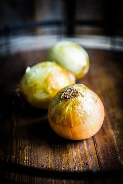 Yellow onions on wooden background