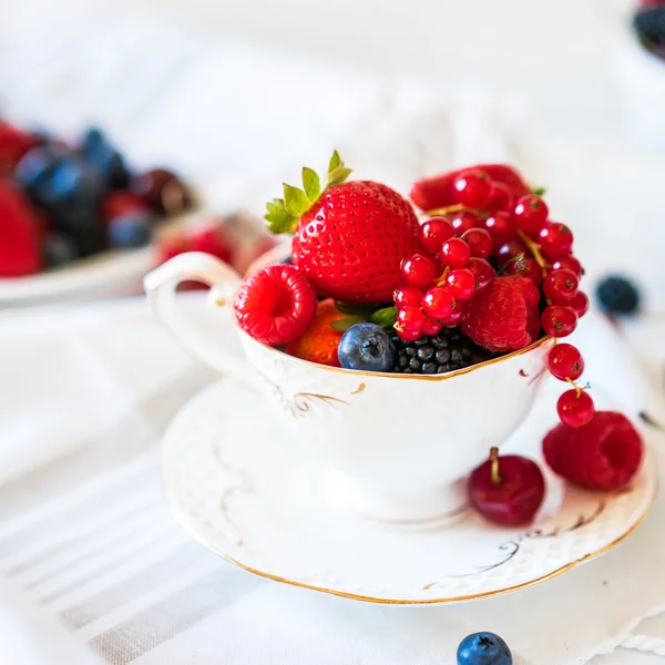 Mischung aus frischen Beeren in einer Tasse Tee — Stockfoto