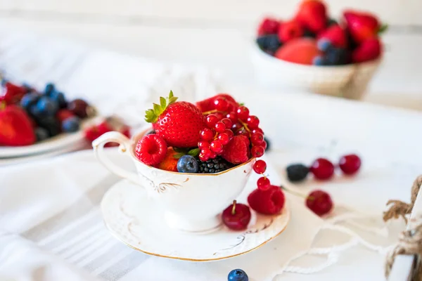 Mix of fresh berries in a cup of tea — Stock Photo, Image