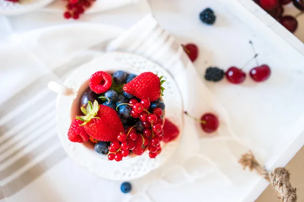 Mix of fresh berries in a cup of tea — Stock Photo, Image