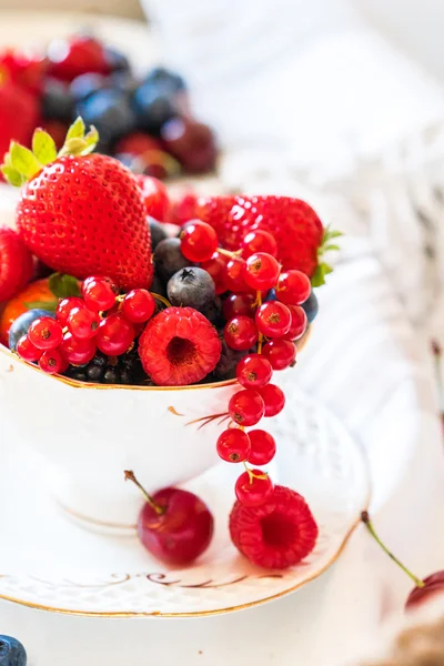 Mix of fresh berries in a cup of tea — Stock Photo, Image