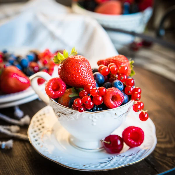 Mix of fresh berries in a cup of tea — Stock Photo, Image