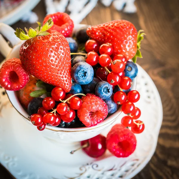 Mix of fresh berries in a cup of tea — Stock Photo, Image