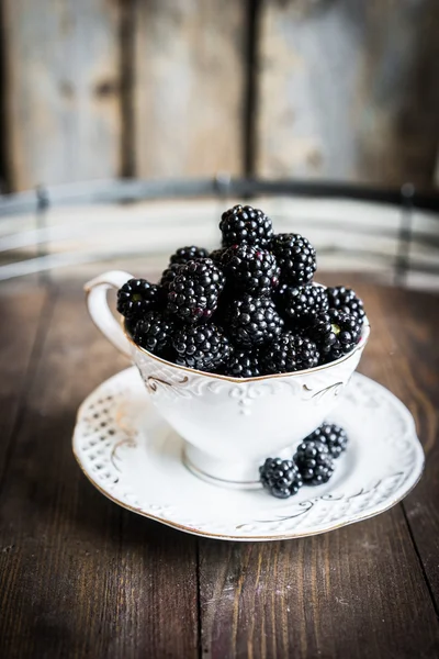 Blackberries in a mug on wooden background — Stock Photo, Image