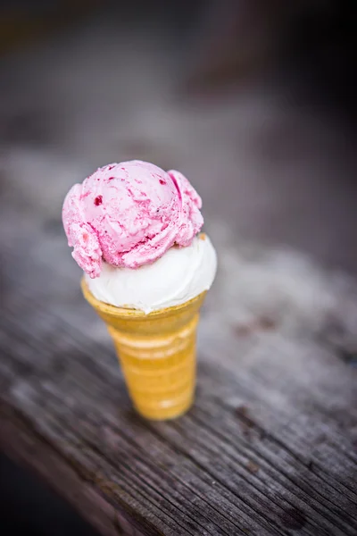 Cono di cocco e gelato alla fragola su fondo di legno — Foto Stock