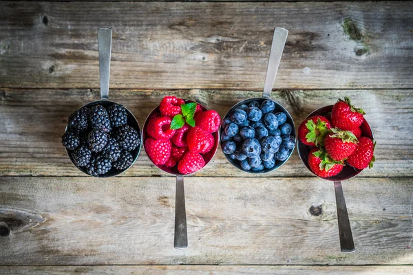 Mischung aus frischen Beeren auf rustikalem Hintergrund — Stockfoto