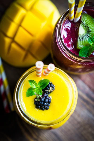 Mango ve rustik wo üzerinde meyveleri ile renkli iki katman smoothies — Stok fotoğraf