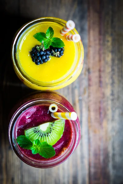 Colorful two layer smoothies with mango and berries on rustic wo — Stock Photo, Image