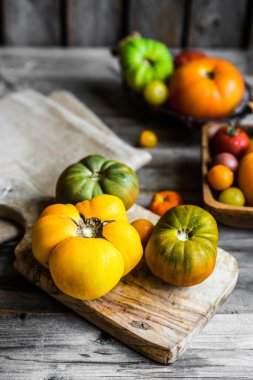 Rustik ahşap arka plan üzerinde renkli hatıra domates