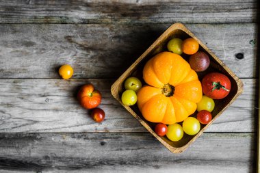 Rustik ahşap arka plan üzerinde renkli hatıra domates