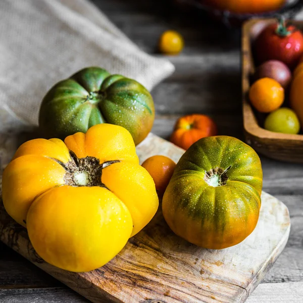 Tomates herederos coloridos sobre fondo rústico de madera —  Fotos de Stock