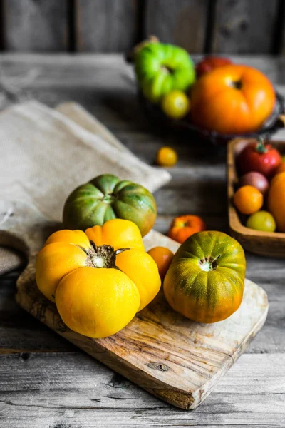 Tomates herederos coloridos sobre fondo rústico de madera — Foto de Stock