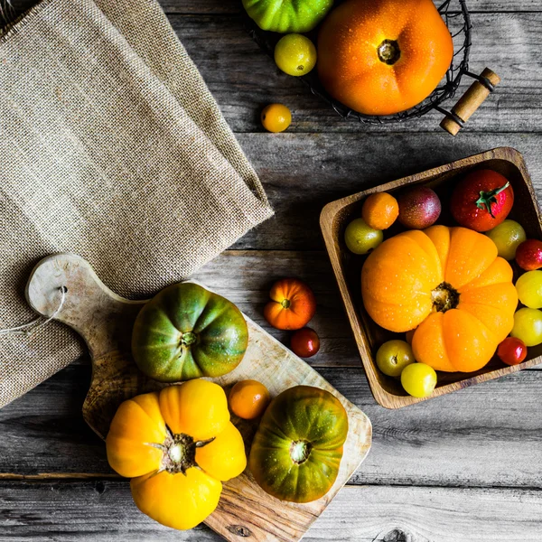 Tomates herederos coloridos sobre fondo rústico de madera —  Fotos de Stock