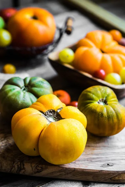 Tomates herederos coloridos sobre fondo rústico de madera —  Fotos de Stock