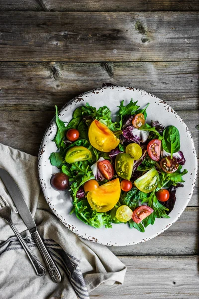 Fräsch sallad med spenat, rucola och heirloom tomater på rustik — Stockfoto