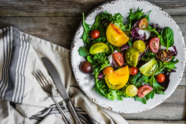 Frischer Salat mit Spinat, Rucola und Tomaten auf rustikalem — Stockfoto